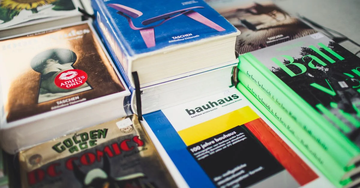 Un éventail coloré de livres sur le design et la littérature, parfait pour les amateurs d'art et de bandes dessinées.